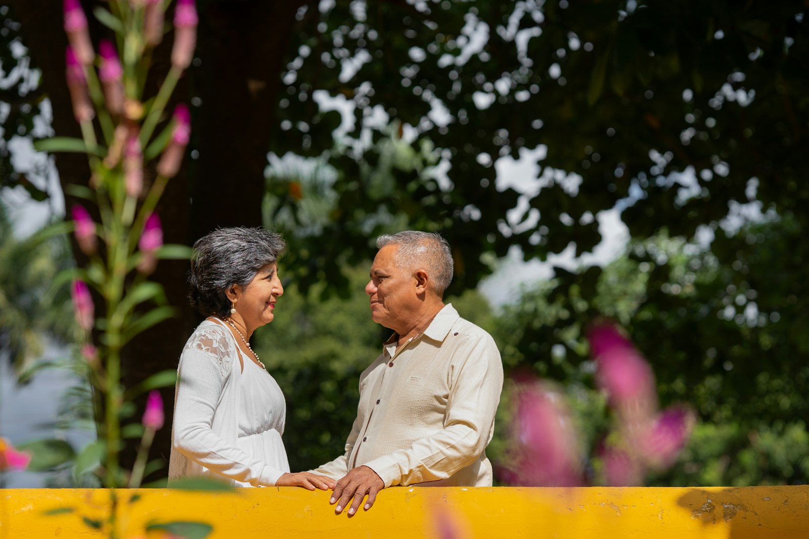 An older couple smiling together in a garden